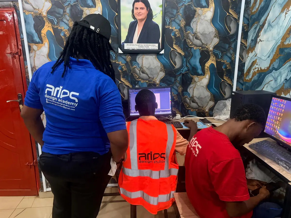 An instructor guiding students at their computers in the Aries studio